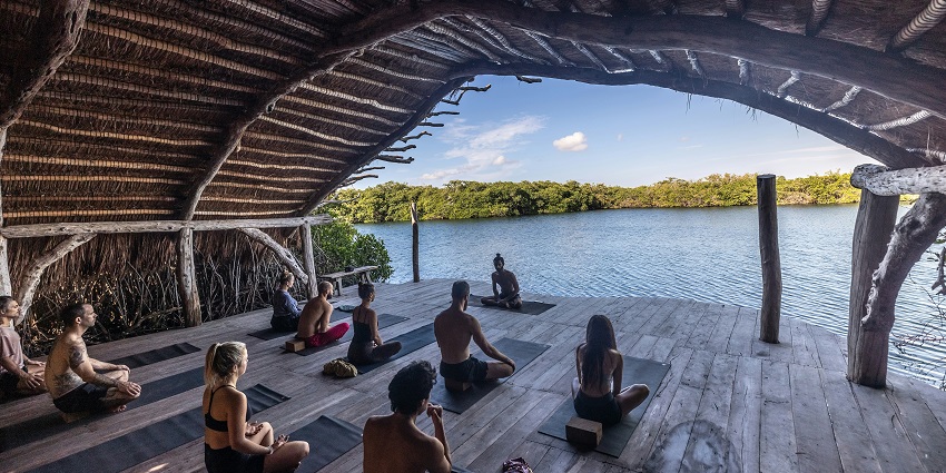 An image of a group of women practising yoga, a peaceful thing to do in Auroville, India.