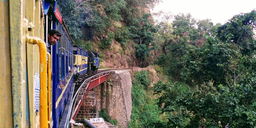 The Nilgiri Mountain Railway train travelling through the scenic hills of Tamil Nadu.