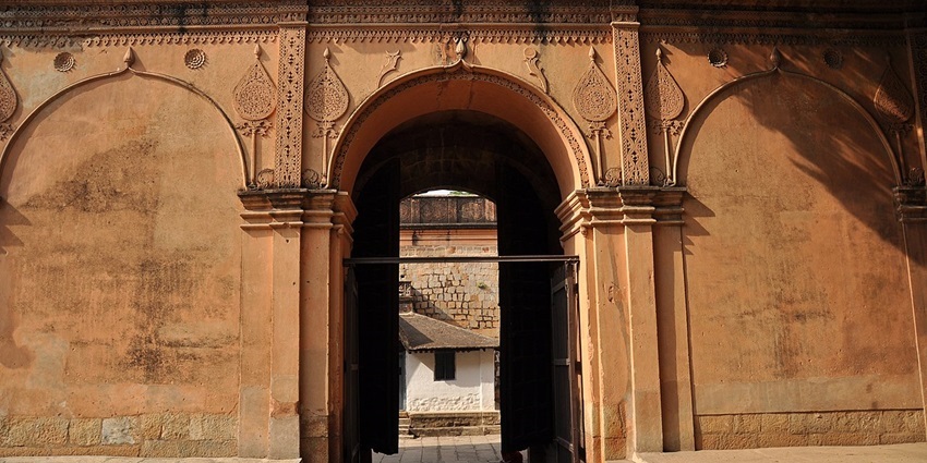 A front view of the Old Bangalore Fort featuring stone walls with arched gateways.