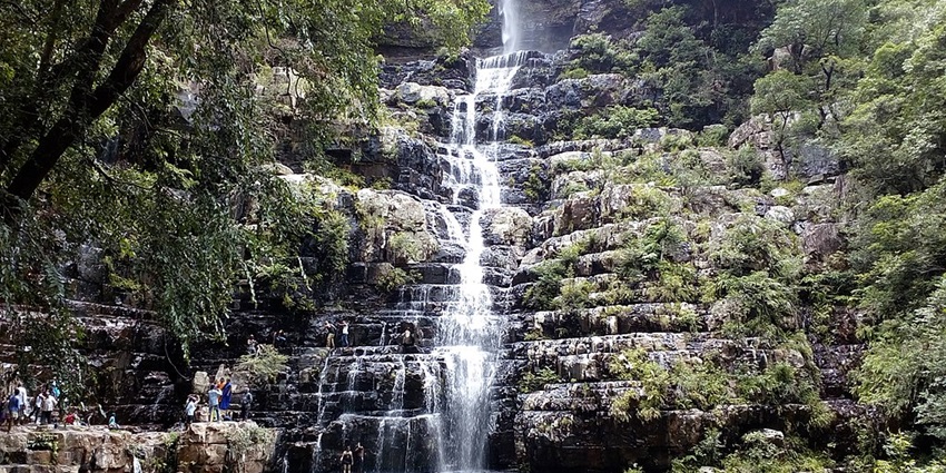 A view of a famous waterfall near Chennai cascades from green hills with scenic beauty.