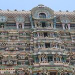 Kaasi Viswanathar Tenkasi Temple is filled with sculptures of idols against the vividly colourful wall.