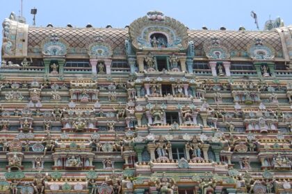 Kaasi Viswanathar Tenkasi Temple is filled with sculptures of idols against the vividly colourful wall.