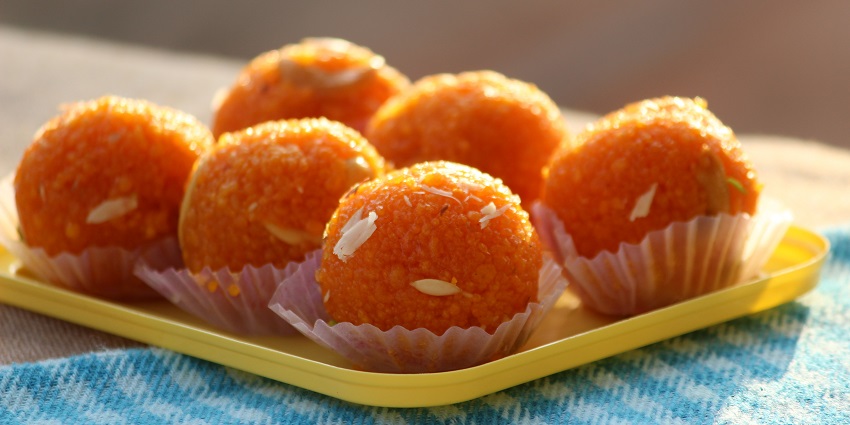 A picture of a plate full of Laddus, a traditional Indian spherical sweet made with flour and fat