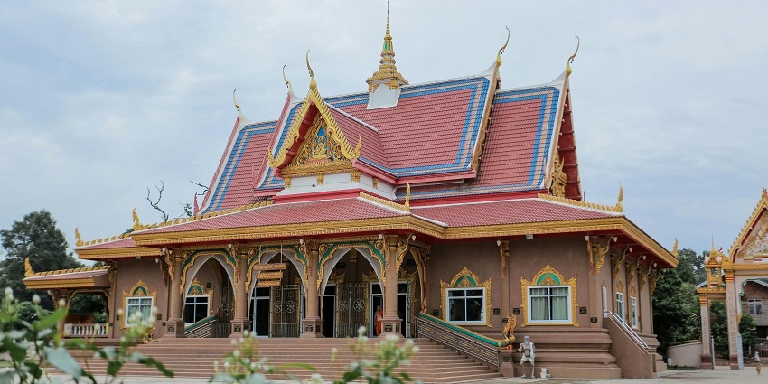 A view of the iconic Thai Temple surrounded by lush green vegetation in Uttar Pradesh.