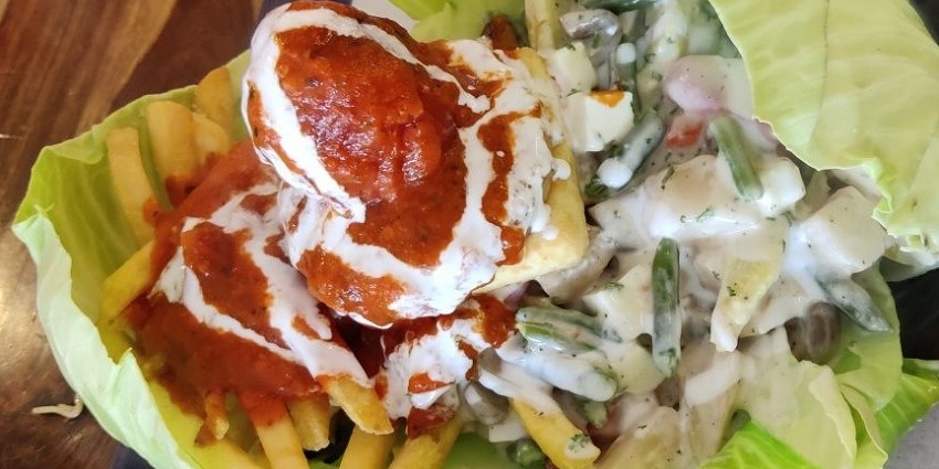 A lip-smacking continental sizzler being served with the salad and other food items in the city