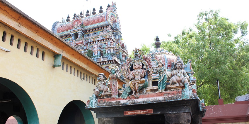 Thillai Kali Temple with colourful detailed gopuram surrounded by temple walls and trees.