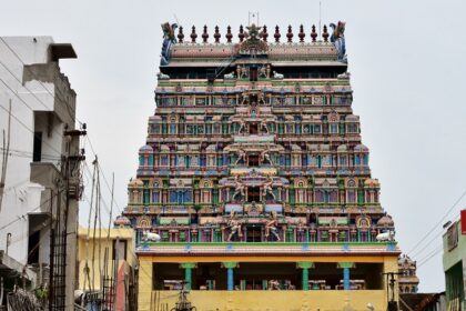 A picture of a decorated temple tower exhibiting a lot of work in a close-up shot.