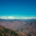 A breathtaking vista of majestic peaks, rustic terrains, and misty clouds in Uttarakhand.