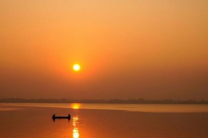 A Lakeside view represents the early sunrise over the city's horizon and Fishermen