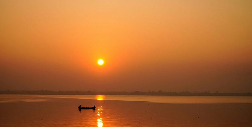 A Lakeside view represents the early sunrise over the city's horizon and Fishermen