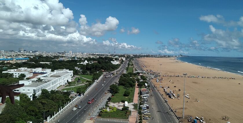 Aerial view of Chennai city with buildings, roads, and greenery visible from above.