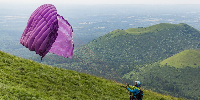 A picture of a professional paraglider in the verdant hills of New Tehri in Uttarakhand