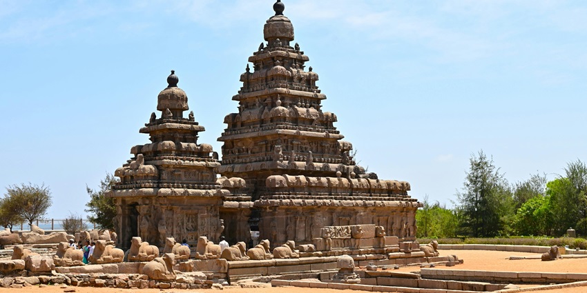 A woman in a dress standing inside an old temple, showcasing its architectural details.