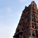 Panchalingeswar temple with intricate colourful stone carvings against a clear blue sky