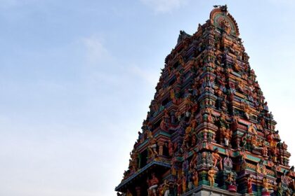 Panchalingeswar temple with intricate colourful stone carvings against a clear blue sky