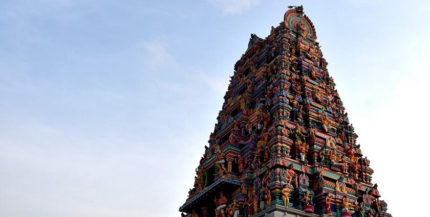 Panchalingeswar temple with intricate colourful stone carvings against a clear blue sky