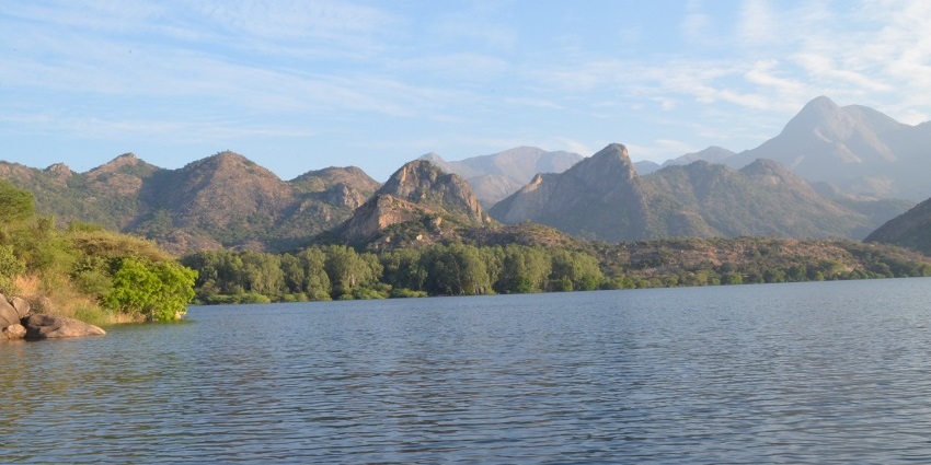 Thirumoorthy Hills with a lake in the foreground lies near the Thirumuruganpoondi Temple