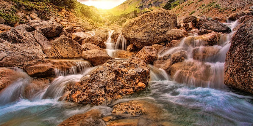 A sunny view of an amazing waterfall resembling the Thirumoorthy Waterfalls