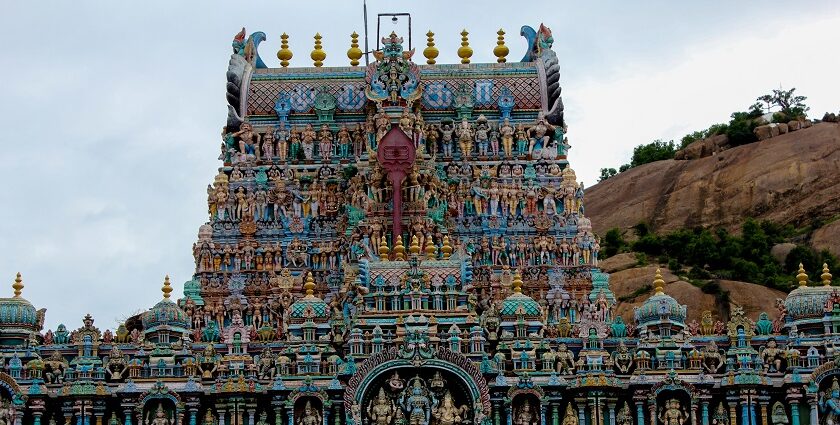 A view of the Thiruparankundram Temple adorned with intricate carvings under clear skies.