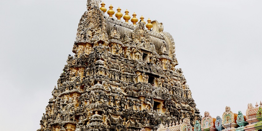 Temple with intricate carvings and stunning structure under a misty sky.