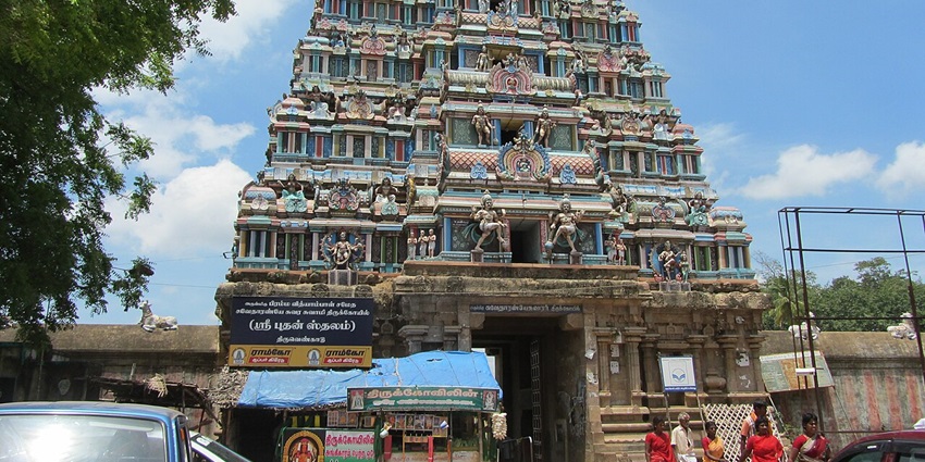 An image of a Thiruvengadu Temple showing the entrance and sculptures, surrounded by trees
