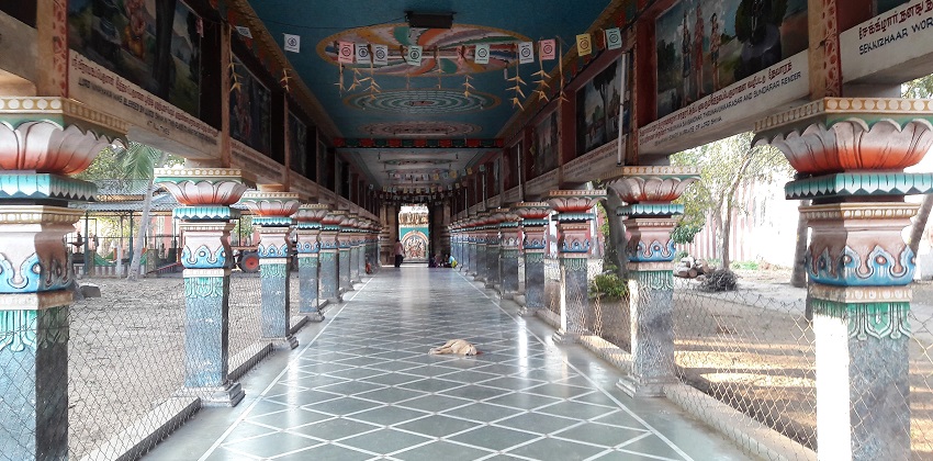 Inside view of Temple showing a beautiful walkway with few persons seating at one end