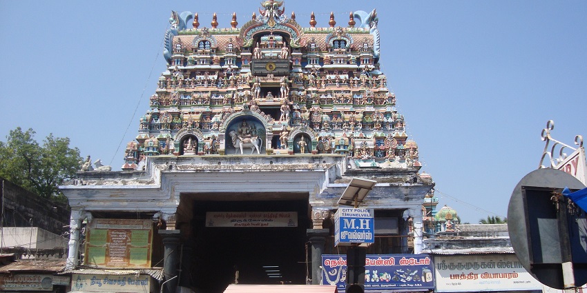 Outside of Nellaiappar Temple and its tower with intricate sculptures and vibrant colours