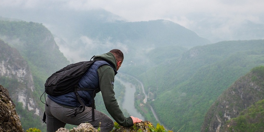 A picture of a person trekking at Selur Viewpoint overlooking the lush green valleys.