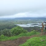 A scenic picture of a man with his dog trekking in Maharashtra amidst the most scenic monsoon.