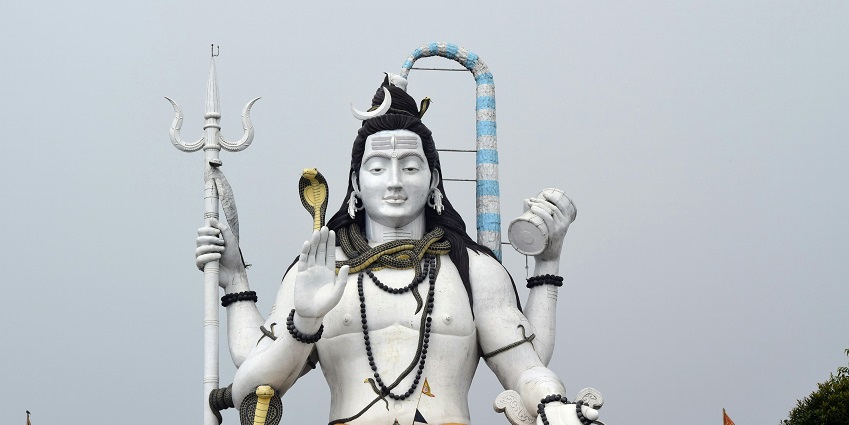 A picture of a statue of Lord Shiva at Trivati Nath Temple under a clear white sky.