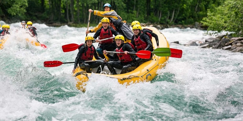 A group of tourists river rafting which is one of the fun things to do in Rishikesh.