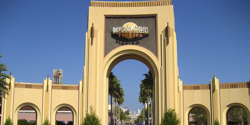 The entrance of Universal Studios Florida with big yellow gate and signage on top of it
