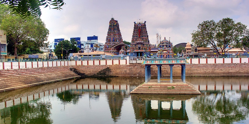 Temple tank at Vadapalani Murugan Temple with calm water reflecting surrounding structures