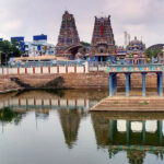 Water tank at Vadapalani Murugan Temple, surrounded by temple structures and gopurams.