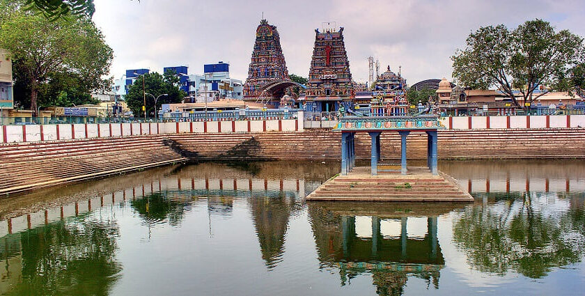 Water tank at Vadapalani Murugan Temple, surrounded by temple structures and gopurams.