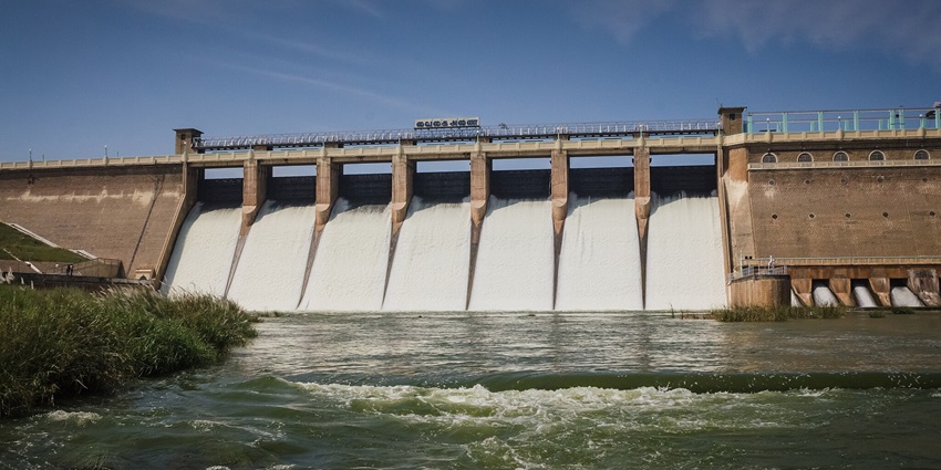 A view of a dam, a popular tourist attraction near the waterfalls, with scenic gardens.