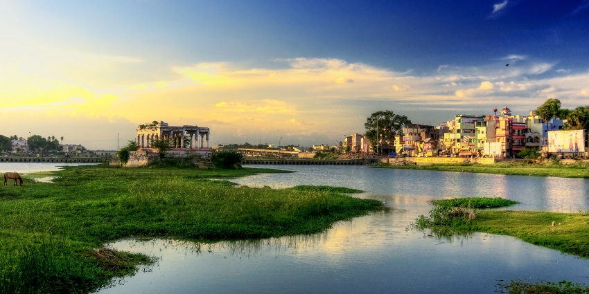 A breathtaking sunrise casts a golden glow over the peaceful Vaigai River in Madurai.