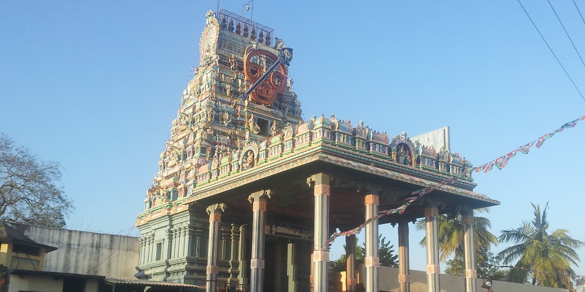 Vallakottai Murugan Temple with an intricate tower, people outside, and parked vehicles