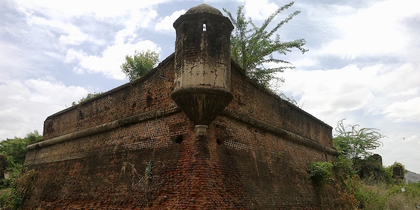 Vandavasi Fort structure with ruined architecture surrounded by a grassy landscape