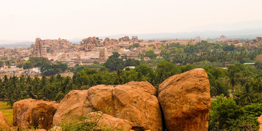 Image of a landscape of mountains and temples resembling Vandiyur Mariamman Temple