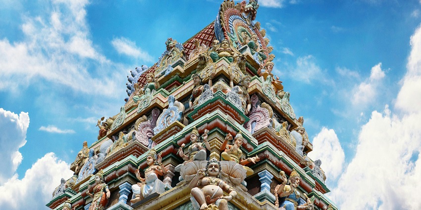 Low-angle view of a tall temple with intricate architecture and ornate details.