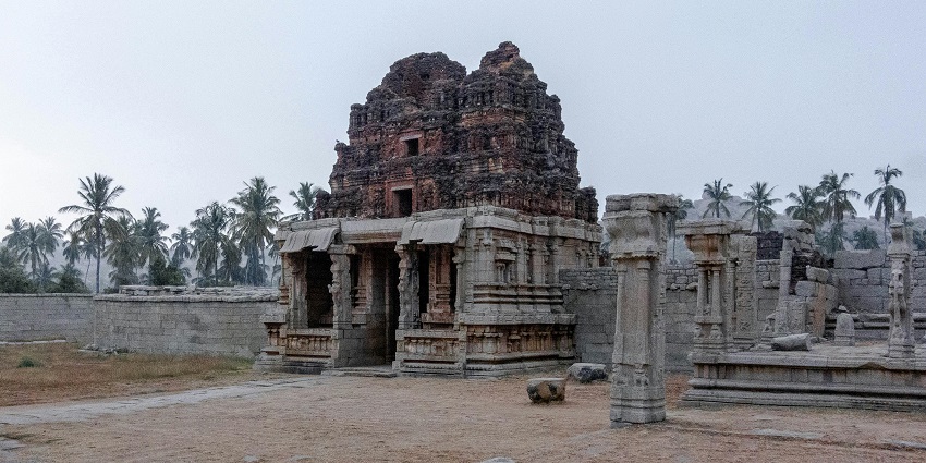 Ancient stone temple ruins with detailed carvings at Hampi, India.