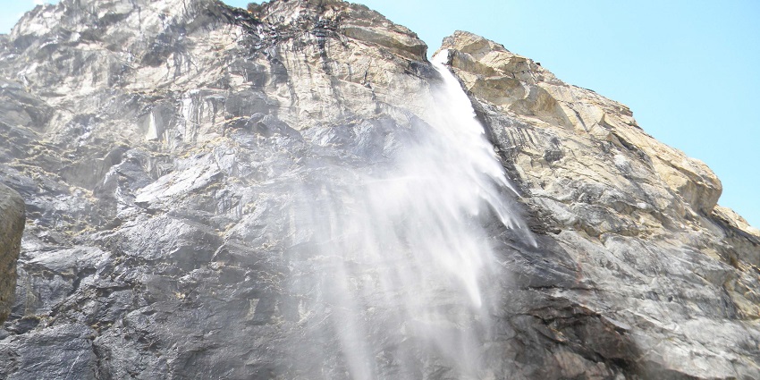 Majestic waterfall cascading down lush green mountains in Uttarakhand