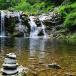 An image depicting a magnificent waterfall cascading into a peaceful lake below