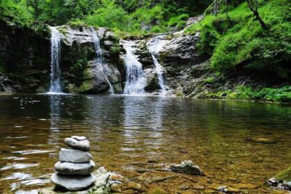 An image depicting a magnificent waterfall cascading into a peaceful lake below