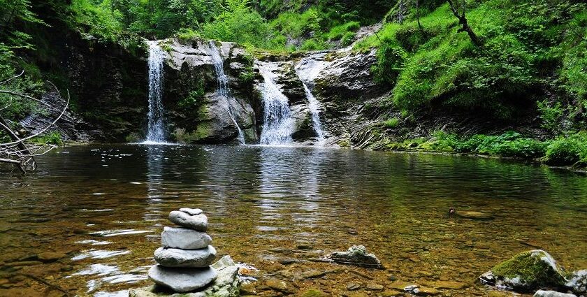 An image depicting a magnificent waterfall cascading into a peaceful lake below