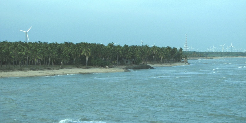 A view from Vattakottai Fort overlooking the coastline and ocean, surrounded by lush greenery.