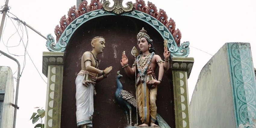 The Lord Murugan, with his peacock, blessing the sage at the entrance of the temple.