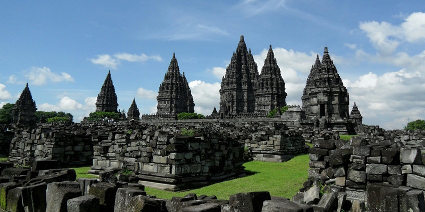 An image showing grey concrete temples under a blue sky, resembling Velliambalam Temple.