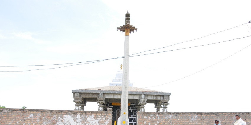 An image showing Venkateshwara Swamy Temple that has intricate architecture, and devotees gather outside.